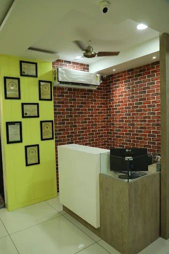 A welcoming reception space featuring a brick wall accent, framed certificates, and essential amenities like an air conditioner and ceiling fan.